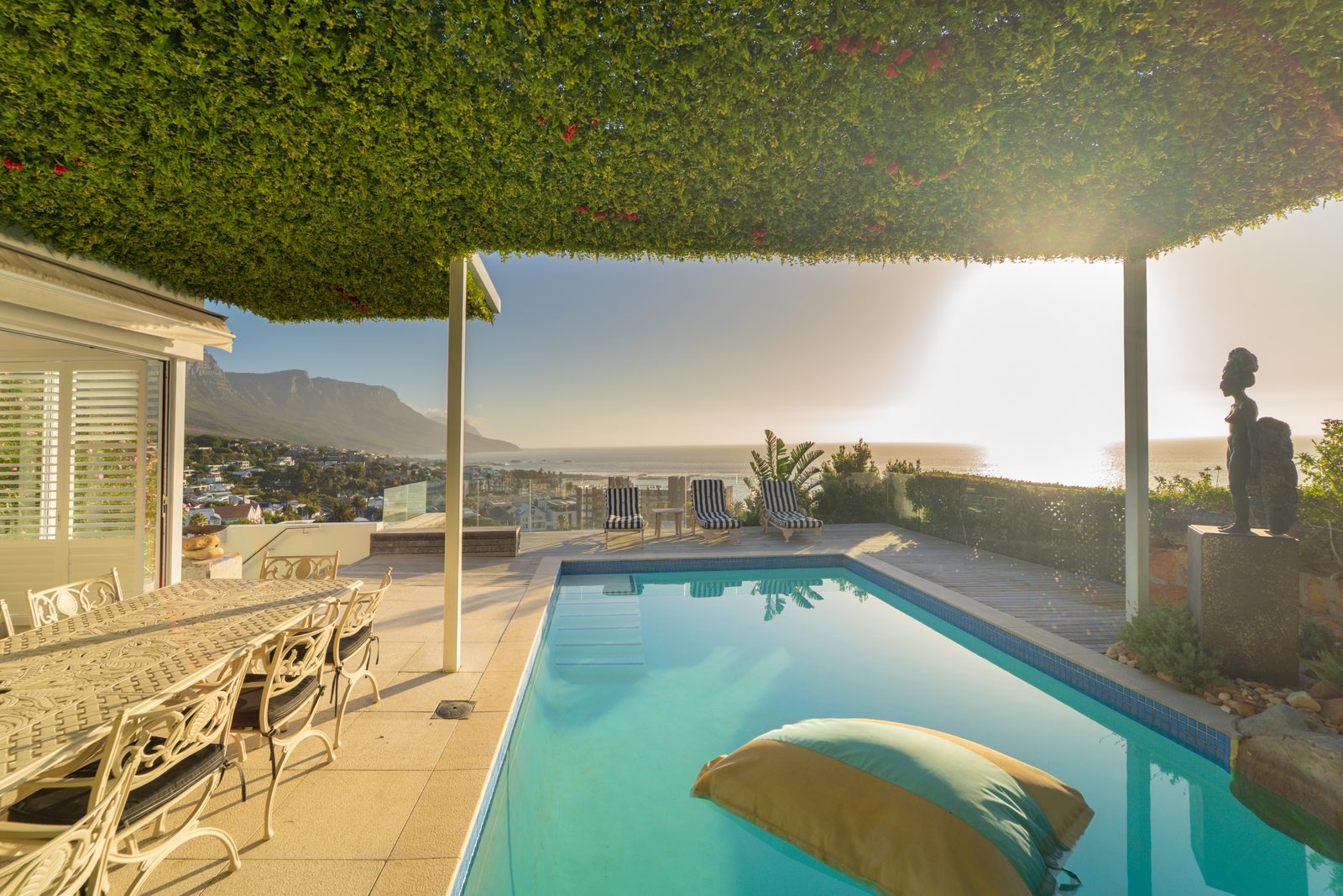 The rooftop terrace lit at dusk above the lights of Camps Bay