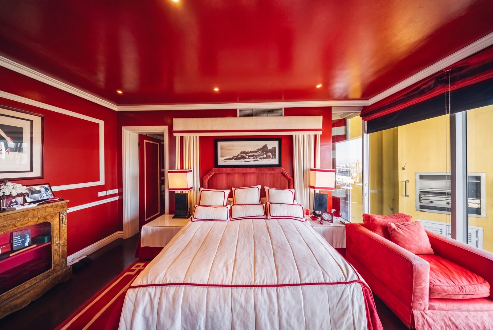 The primary suite in red Chinese lacquer, its canopied bed