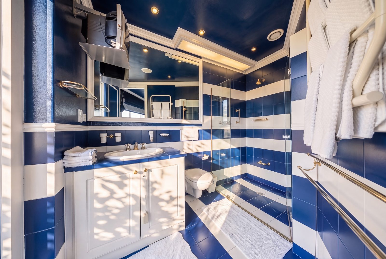 The second bedroom's en suite, banded tiling and walk in shower